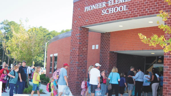 Parents and students line up at the front entrance of Pioneer Elementary School to learn which classroom and teacher children are assigned to.