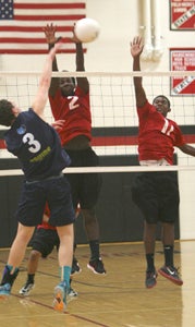 Nansemond River High School senior Malcolm Nurse, No. 2, and junior Davontrez Wallace, No. 11, seek to block the visiting Western Branch High School hitter on Tuesday. The Warriors lost in straight sets.