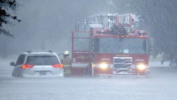 Suffolk Fire and Rescue’s Ladder 5 assists a stranded motorist in the Burbage Grant area on Monday afternoon. More than nine inches of rain fell in about four hours, a city spokeswoman said, prompting a flash flood warning and a flood advisory that continues today.