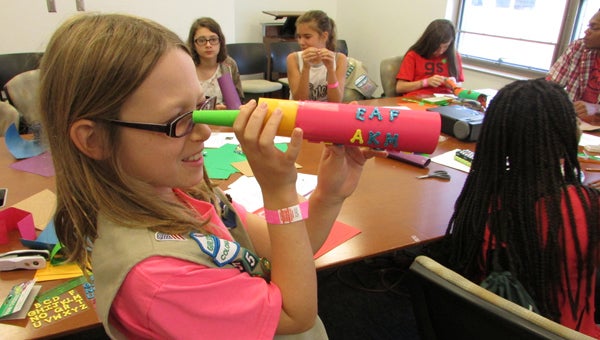 Suffolk resident and Girl Scout Cadette Emily Farmer tests out the telescope she built during an engineering workshop at Science Alive, hosted by Norfolk State University for Girl Scouts on Sept. 27. 