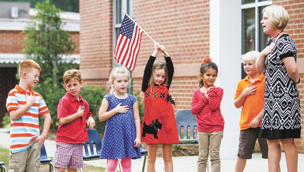 Jennifer Rose’s kindergarten class, from left, Jackson Clinton, 5, of Suffolk, Brayden Donnelly, 5, of Carrollton, Emma Pierce, 5, of Smithfield, Elizabeth Adams, 5, of Carrollton, Victoria Gayle, 5, of Suffolk, Brody Casey, 6, of Smithfield, and Rose led the audience in the Pledge of Allegiance at the dedication of Isle of Wight Academy’s Early Learning Center. (Cain Madden/The Tidewater News)