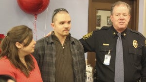 During the grand opening of Kroger Marketplace in North Suffolk on Wednesday, Suffolk Police Chief Thomas Bennett helps open a community room dedicated to James Winslow, a former Suffolk police officer who was brutally beaten while in the line of duty. Winslow stands next to his wife, Sarah Winslow.