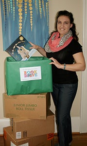 Rachele Hirsch-Brooks stands with some of the boxes of books that were donated through the Suffolk Reading Council to the ForKids Suffolk House and the Genieve Shelter. The council collected more than 1,000 books in its February drive.