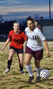 King’s Fork High School sophomore midfielder Rebecca Washburn works the ball against visiting Nansemond River High School on Thursday evening. She was a key reason the Lady Bulldogs achieved their first win against the Lady Warriors.