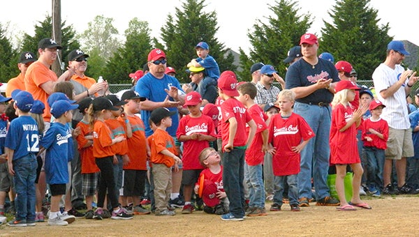 Young Bennett’s Creek Little League players along with coaches and parents gather on a ball field during the BCLL 47th Season Opener event on Friday.