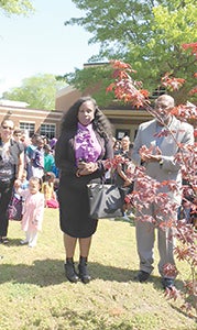 At Booker T. Washington Elementary on Friday, Patricia Montgomery’s daughter, Meagan Montgomery, and husband, Dennis Montgomery, join with members of the school community to remember the former principal, who died in February. On Arbor Day — Friday — a Japanese maple was planted in her memory. (Submitted Photo)