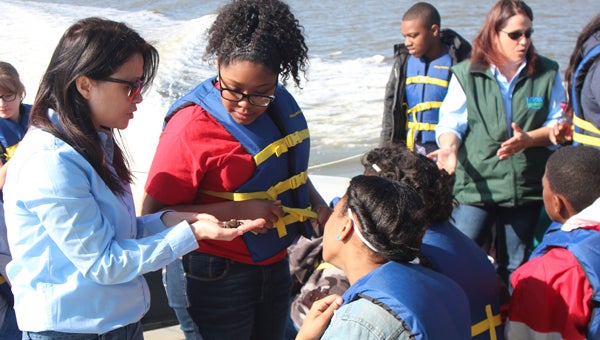 Nansemond River Preservation Alliance volunteer Jennifer Shirley shows John F. Kennedy Middle School students Carlie Shivers and Brittney Miller a juvenile crab. The boat trip in North Suffolk on Wednesday, part of NRPA’s Watershed Initiative, was the day after its river report card sounded a warning for the health of the Nansemond and tributaries.