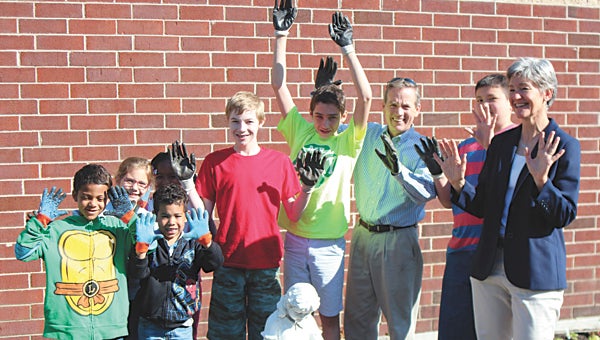In the garden at Oakland Elementary School on Wednesday, students Londyn Plummer, Christina Blakeman, Adrianna Bradshaw, Maddox Haynes, Bailey Cobbs, William Bennett and Paul Flynn celebrate getting their hands dirty with Delegate Chris Jones and Shelley Barlow, garden coordinator with Suffolk Partnership for a Healthy Community.