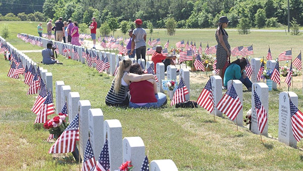 Families mourn at gravesites at Albert G. Horton Jr. Memorial Veterans Cemetery.