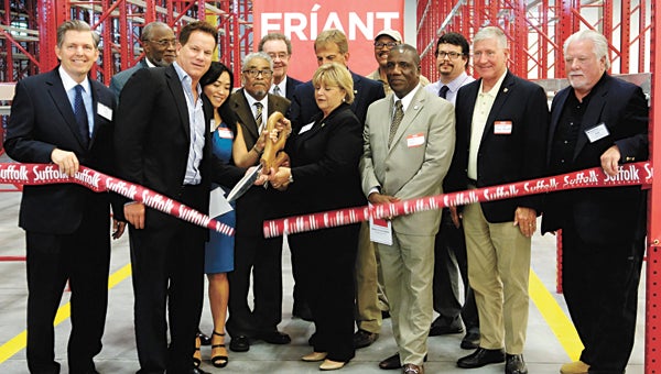 City and company officials cut the ribbon at Friant & Associates’ new manufacturing and distribution facility on Thursday. From left are Barry DuVal, president and chief executive officer of the Virginia Chamber of Commerce; Vice Mayor Leroy Bennett; company founder Paul Friant and his wife, Yia; Councilman Curtis Milteer; Bob Harbour of CenterPoint Properties; Mayor Linda T. Johnson; Councilman Tim Johnson; Economic Development Authority Chairman Harold Faulk; Delegate Lionell Spruill; Marc Friant, West Coast operations manager; Councilman Roger Fawcett; and Scott Bloyd, East Coast operations manager. (City of Suffolk photo)