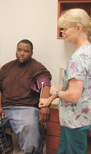 At Western Tidewater Free Clinic on Thursday, volunteer nurse Libby Holdstein takes the blood pressure of 36-year-old Terrance Parker, a new patient. The clinic is in need of more volunteer nurses like Holdstein.