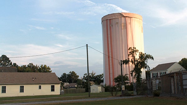 Draped in protective material, the North Suffolk water tower in the Huntersville community is getting a fresh coat of paint.