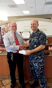 Chick-fil-A operator Dan Curran presents meal cards to Lt. Cmdr. Marc Benshetler from the Joint Staff Suffolk Complex. He presented the meal cards to military, police, firefighters and rescue workers on Sept. 11.