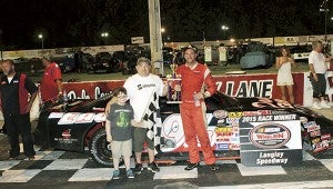 Greg Edwards celebrates with trophy presenter Joe McGuire and son after Edwards won the second of the twin 65-lap Late Model Stock Cars races in the NASCAR Whelen All-American Series events Saturday at Langley Speedway. His brother, Danny Edwards, finished second. (Bill Carr/MotorSports Photo News Service)
