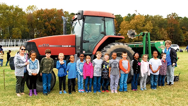 Amy Lemasters and her second-grade students from Northern Shores Elementary School take a photo in front of a tractor during Farm Day.