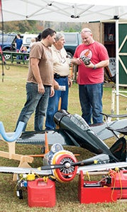At left, Mariusz Ostasz, Bob Howell and Dave Parker take a look at an engine similar to the ones that power the aircraft in the foreground.