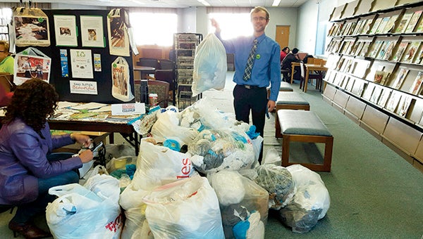 Wayne Jones, litter control coordinator and spokesperson for Keep America Beautiful, stands at Morgan Memorial Library with some of the bags full of plastic bags that were collected during a recycling event on Saturday.