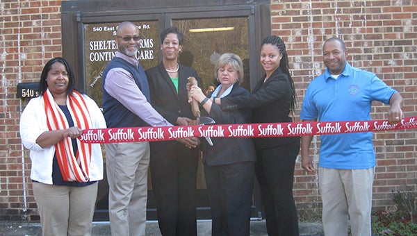 Mayor Linda T. Johnson helps the owners and staff of Sheltering Arms Continuing Care cut the ribbon at its new location at 540 E. Constance Road. The facility provides support for adults with intellectual or developmental disabilities.