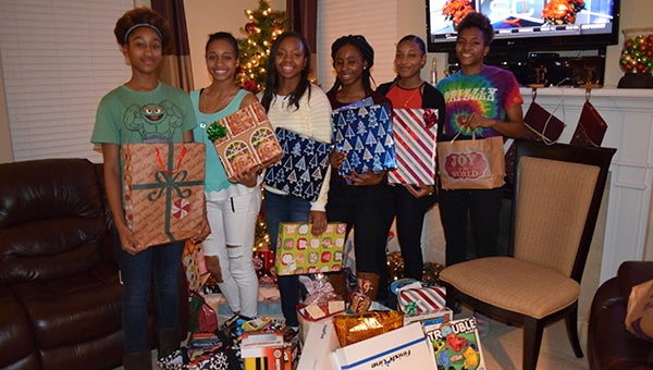 Members of the Nansemond River High School girls’ basketball team display their handiwork, having wrapped a variety of presents for the Meeks, the Lady Warriors’ adopted family. From left: Arielle Abdullah, Cassidy Simmons, Briana Autrey, Tashira Burch, Nijah Shannon and Aneka Yelverton. (Photo submitted by R. Calvin Mason Sr.)