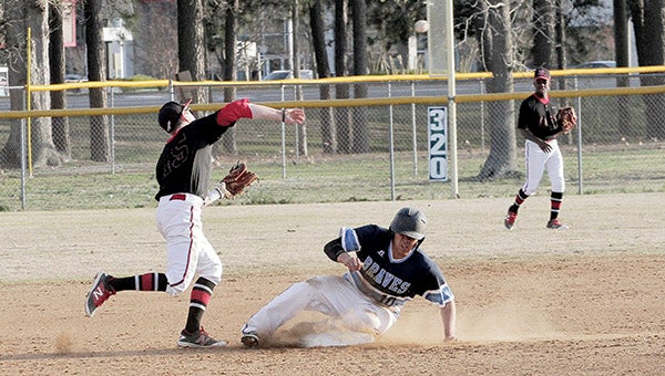 Nansemond River High School senior Nick Lees, standing, gets an out at second base during the Warriors’ 5-4 victory over host Indian River High School on Thursday. (Photo by Wil Davis/WilDavisPhotography.com)