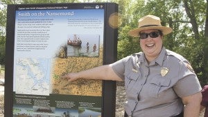 Christine Lucero, partnership coordinator for the National Park Service, points out the newly unveiled John Smith Chesapeake National Historical Trail sign at Sleepy Hole Park, near the kayak launch. 