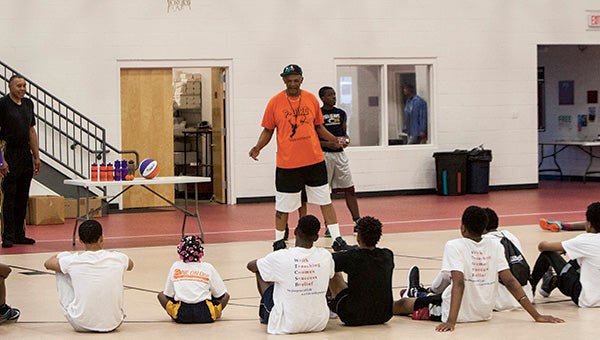 Michael Britt of Suffolk talks to participants of the skills and drills basketball clinic that he ran last week, with help from Joel Copeland, Diego McCoy and Teko Wynder among others.
