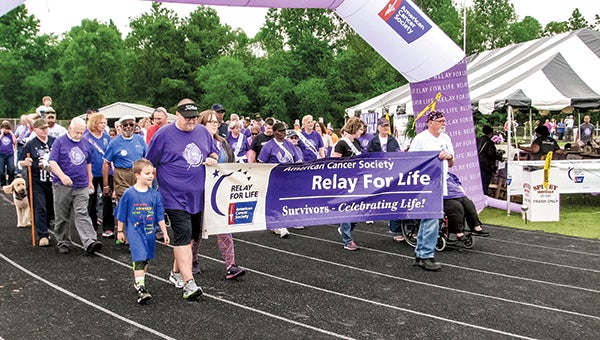 Survivors and caregivers walk the first lap in the Suffolk Relay for Life at Nansemond River High School on Friday evening.