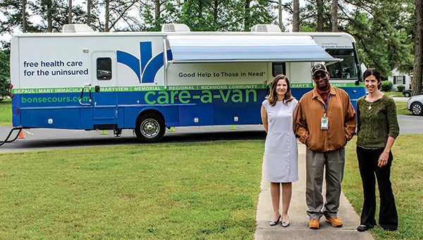 Bon Secours Hampton Roads Care-A-Van staff, from left, Melissa Gornitzka, Dr. Emily Leib and Gursha Holmes, stand outside the mobile unit that comes to Suffolk every Friday.