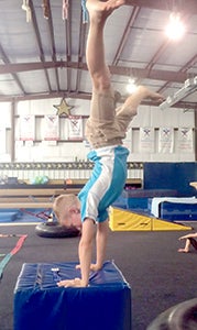 Chris Winoski practices a handstand while at Triple T’s summer camp. Winoski and several other campers spent the weekend at Triple T, watching the qualifying rounds of men’s and women’s gymnastics. 