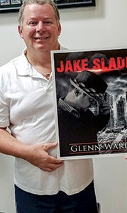 Glenn Ward poses with his first book, Jake Slade.